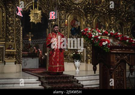 24. April 2022, Bucha, Kiew, Ukraine: Ein Priester wird mit einer Kerze gesehen. Die orthodoxe Osterdienst in der Nacht - von späten Samstagabend bis zum frühen Sonntagmorgen- gefeiert worden war im Inneren St. MichaelÂ €™s Golden Domed Cathedral, in Kiew, in Anwesenheit der Metropolitan Epifany, der Klerus und nur wenige Menschen, aufgrund der nationalen Ausgangssperre. Die Zeremonie wurde für Online-Streaming für engagierte Menschen aufgezeichnet. (Bild: © Valeria Ferraro/ZUMA Press Wire) Stockfoto