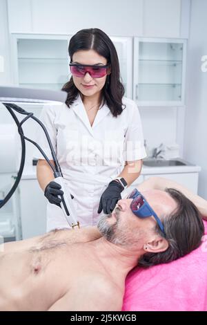 Professionelle Kosmetologe tun Laser-Haarentfernung Behandlung Stockfoto