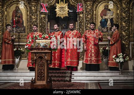 Bucha, Kiew, Ukraine. 24. April 2022. Priester sahen Lieder singen. Der orthodoxe Ostergottesdienst in der Nacht - vom späten Samstagabend bis zum frühen Sonntagmorgen - wurde in der Golden Domed Cathedral von St. Michael in Kiew im Beisein des Metropoliten Epifany, des Klerus und einiger weniger Menschen aufgrund der nationalen Ausgangssperre gefeiert. Die Zeremonie wurde für Online-Streaming für engagierte Menschen aufgezeichnet. (Bild: © Valeria Ferraro/ZUMA Press Wire) Stockfoto