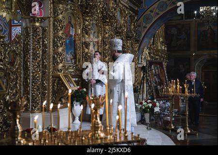 Bucha, Kiew, Ukraine. 23. April 2022. Ein Priester zu Beginn des Dienstes gesehen. Der orthodoxe Ostergottesdienst in der Nacht - vom späten Samstagabend bis zum frühen Sonntagmorgen - wurde in der Golden Domed Cathedral von St. Michael in Kiew im Beisein des Metropoliten Epifany, des Klerus und einiger weniger Menschen aufgrund der nationalen Ausgangssperre gefeiert. Die Zeremonie wurde für Online-Streaming für engagierte Menschen aufgezeichnet. (Bild: © Valeria Ferraro/ZUMA Press Wire) Stockfoto