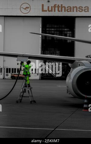 Mitarbeiter, die ein lufthansa-Flugzeug vor der lufthansa-Werkstatt inspizieren Stockfoto