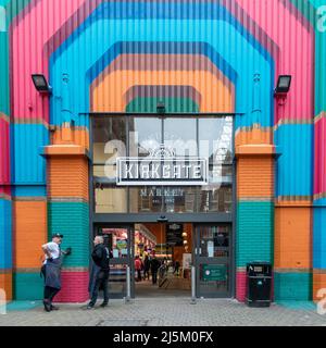 Leeds Kirkgate Market farbenfroher Seiteneingang mit zwei Markthändlern, die eine Pause machen und sich draußen unterhalten, Leeds City Centre, West Yorkshire, England Stockfoto