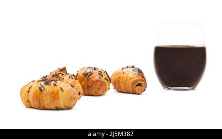 Mit Schokolade bestreute Croissants mit einem Glas Schokolade Stockfoto