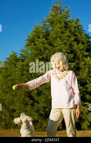 Ältere Frau mit ihrem älteren Cockapoo-Hund Stockfoto