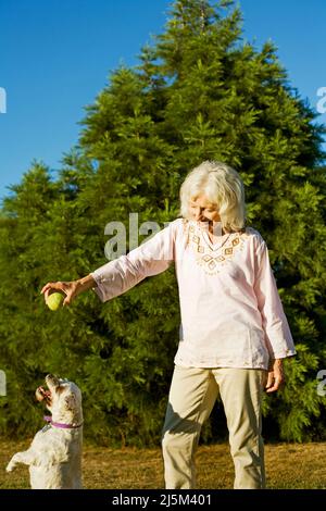 Ältere Frau mit ihrem älteren Cockapoo-Hund Stockfoto