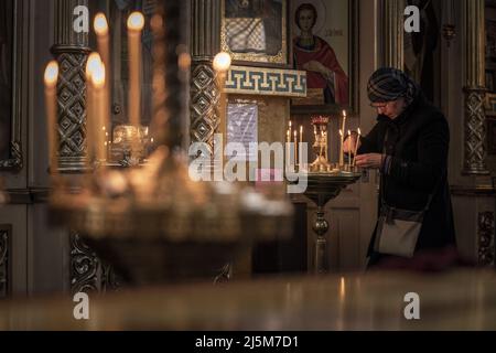 Irpin, Ukraine. 24. April 2022. Am Sonntag, den 24. April 2022, stellt eine Frau während der Ostergottesdienste in der Kirche des heiligen Nikolaus des Wundertäters der Ukrainischen Orthodoxen Kirche in Irpen, Ukraine, eine Kerze auf. Der Generalsekretär der Vereinten Nationen, António Guterres, wird am Dienstag in Moskau mit dem russischen Präsidenten Wladimir Putin und dem russischen Außenminister Sergej Lawrow zusammentreffen. Foto von Ken Cedeno/UPI Credit: UPI/Alamy Live News Stockfoto