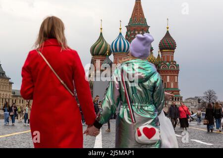 Moskau, Russland. 24.. April 2022. Am bewölkten Frühlingstag auf dem Roten Platz im Zentrum der Stadt Moskau spazieren die Menschen vor dem Hintergrund der Basilius-Kathedrale, Russland Stockfoto
