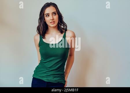Frau träumt mit Händen auf Taschen Blick zur Seite auf Copy Space Studio Portrait Stockfoto