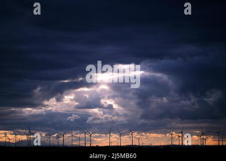 Dunkle Wolken Bei Sonnenuntergang Mit Windmühlen Im Hintergrund In Österreich Stockfoto