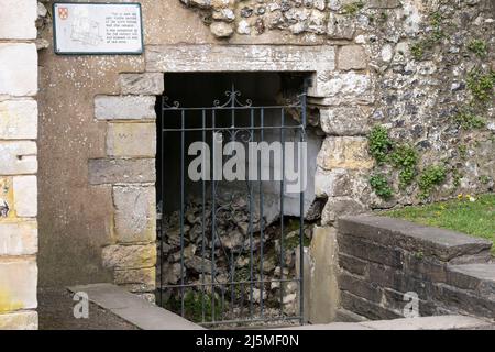 Eine Tafel mit der Aufschrift „Dies ist jetzt der einzige sichtbare Teil der römischen Stadtmauer, der noch erhalten ist...“ neben einer ruinierten römischen Mauer. Winchester, England Stockfoto