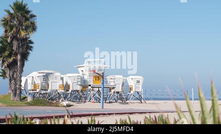 Rettungsschwimmerstand und Palme, Rettungsschwimmerturm zum Surfen am kalifornischen Strand. Sommer pazifik in USA Ästhetik. Ikonische Rettungsstation baywatch, Küstenlebensretter Wachtower Hütte oder Haus am Meer. Stockfoto