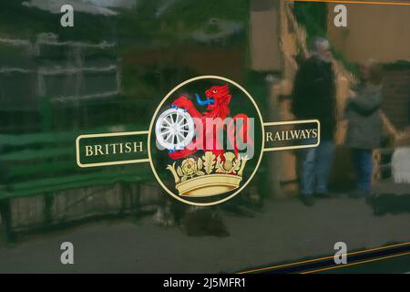 Traditionelles Wappen der British Railways mit Wappen eines Löwen und eines Rades, das auf der Seite eines Wagens auf der Watercress Line gemalt ist. England Stockfoto