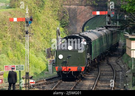 30925 Schools Class Dampflokomotive, die ihre Wagen auf der traditionsreiche Watercress Line in den Bahnhof von Alresford einfährt. Hampshire. England Stockfoto