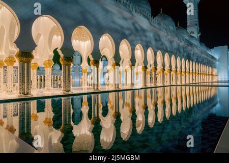 Abu Dhabi, Vereinigte Arabische Emirate - 2022. Februar: Scheich-Zayed-Moschee in Abu Dhabi am Abend mit erstaunlichen Nachdenken. Stockfoto