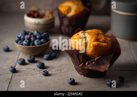 Süßes hausgemachtes Gebäck, Muffin mit Blaubeeren und frischen Beeren auf Steingrund. Stockfoto