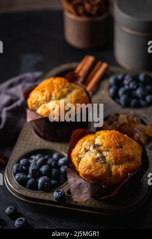 Süßes hausgemachtes Gebäck, Muffin mit Blaubeeren und frischen Beeren auf dunklem Hintergrund. Stockfoto