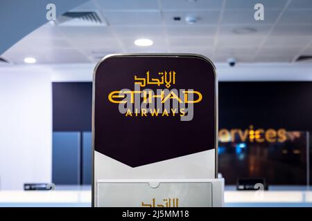 Abu Dhabi, VAE - 2022. April: Check-in-Schalter von Etihad Airways mit Logo am Abu Dhabi International Airport. Etihad Airways ist die zweite Fluggesellschaft A Stockfoto