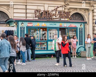 Bukarest, Rumänien - 04.08.2022: Urbane Szene mit vielen Menschen vor einem Pfannkuchen-Food-Truck in der Altstadt von Buchares. Stockfoto