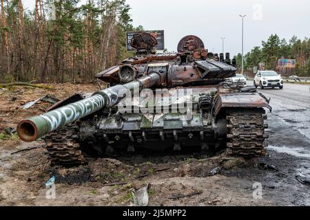 2022-04-09 Kiew, Ukraine. Zerstörter russischer Panzer mit Wolverines Malerei im Schlamm auf der Autobahn E40 in der Nähe von Kiew verstaute. Krieg in der Ukraine Stockfoto