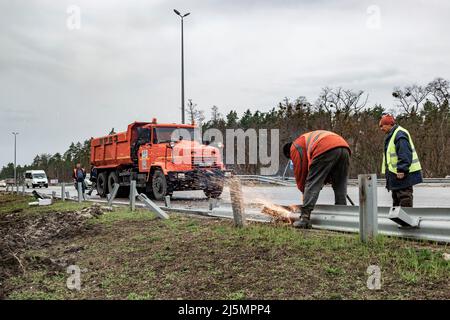 2022-04-09 Kiew, Ukraine. Straßenarbeiter reparieren beschädigte Autobahn E-40 nach dem russischen Beschuss. Krieg in der Ukraine Stockfoto
