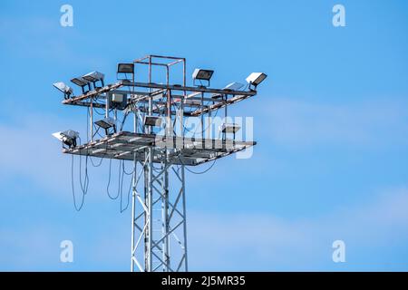 Helsinki / Finnland - 24. APRIL 2022: Nahaufnahme eines hohen industriellen Lichtmastes vor einem strahlend blauen Himmel Stockfoto
