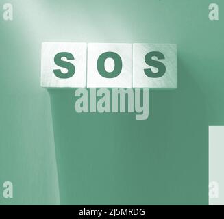 SOS-Symbol auf Holzwürfeln. Rette unsere Seelen rufen um Hilfe Konzept. Stockfoto