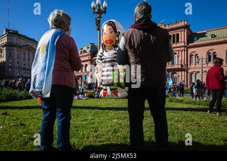 Buenos Aires, Argentinien. 23. April 2022. Zwei Demonstranten beobachten die Marionette von Cristina Kirchner, Vizepräsidentin Argentiniens, die sich während des Protestes auf dem Mayo-Platz auf seine gerichtlichen Korruptionsfälle bezieht. Die Traktoren der argentinischen Landproduzenten wurden auf den Mayo-Platz in Buenos Aires mobilisiert, um gegen den Steuerdruck zu protestieren, den die argentinische Landschaft konsumiert, und gegen die Intervention der nationalen Regierung auf dem Getreide- und Fleischmarkt. Kredit: SOPA Images Limited/Alamy Live Nachrichten Stockfoto