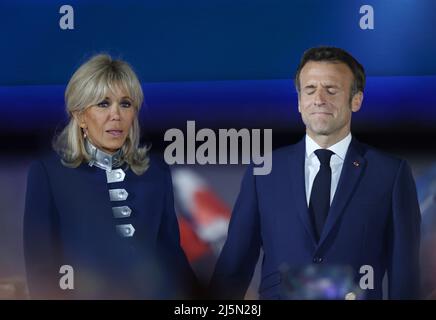 Paris, Frankreich. 24. April 2022. Der amtierende französische Präsident Emmanuel Macron und seine Frau Brigitte Macron nehmen am 24. April 2022 an einer Kundgebung nach dem Präsidentschaftswahlkampf in Paris, Frankreich, Teil. Der amtierende französische Präsident Emmanuel Macron gewann die Stichwahl des französischen Präsidenten 2022 mit 58 Prozent der Stimmen, so die vorläufige Austrittsumfrage, die am Sonntagabend vom französischen Fernsehen BFMTV veröffentlicht wurde. Macrons Rivalin, die rechtsextreme Kandidatin Marine Le Pen, gewann 42 Prozent der Stimmen. Kredit: Gao Jing/Xinhua/Alamy Live Nachrichten Stockfoto