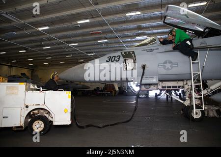 Segler, die der USS Gerald R. Ford (CVN 78) und den „Tomcaters“ des Strike Fighter Squadron (VFA) 31 zugewiesen wurden, führen an einem F/A-18E Super Hornet in der Hangarbucht des Schiffes am 21. April 2022 Überprüfungen der Freigabe- und Kontrollkomponenten durch. Ford führt derzeit im Atlantischen Ozean vor dem operativen Einsatz Qualifikationen von Fluggesellschaften und die Integration von Streikgruppen durch. (USA Navy Foto von Mass Communication Specialist 2. Klasse Zack Guth) Stockfoto