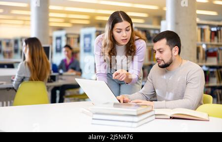 Schülerinnen und Schüler bereiten sich gemeinsam auf die Prüfung in der Bibliothek vor Stockfoto