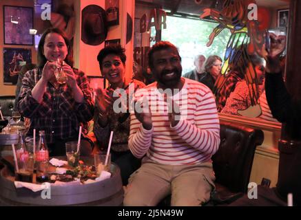 Paris, Frankreich. 24. April 2022. Französische Unterstützer feiern die Ankündigung der Wiederwahl des scheidenden Präsidenten Emmanuel Macron in Frankreichs Spitzenjob in einem Café in Paris am Sonntag, dem 24. April 2022. Macron besiegt die rechtsextreme Kandidatin Marine Le Pen und . Foto von Maya Vidon-White Kredit: UPI/Alamy Live News Stockfoto