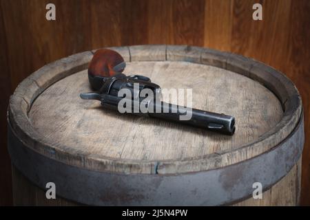 Old West Revolver 45 cal auf vintgenem Holzfass Stockfoto