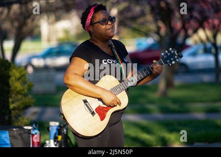 Paisha Thomas, eine Musikkünstlerin, singt und spielt Originallieder auf der Gitarre bei der Gemeindewache von Ma'Khia Bryant, ein Jahr nachdem Ma'Khia Bryant von der Polizei von Columbus angeschossen und getötet wurde. Ein Jahr nachdem Bryant am Samstag, dem 23. April 2022, von der Polizei von Columbus im Alter von 16 Jahren von der Polizei von Columbus angeschossen und getötet wurde, fand im Mayme Moore Park in Columbus, Ohio, eine Mahnwache mit Kerzenlicht und ein Mahnmal für Ma'Khia Bryant statt. Die Schwestern von mA'Khia Bryant, Azariah Bryant, 14, und Ja'Niah Bryant, 16, erschienen zusammen mit ihrer Großmutter, Jeanene Hammonds, und ihrer Tante, Myra Duke. Stockfoto