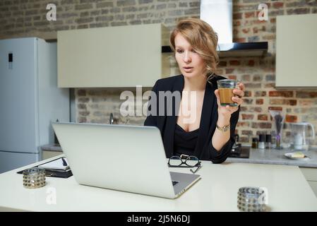 Eine Frau diskutiert bei einem Online-Briefing mit ihren Kollegen zu Hause über das Geschäft. Stockfoto