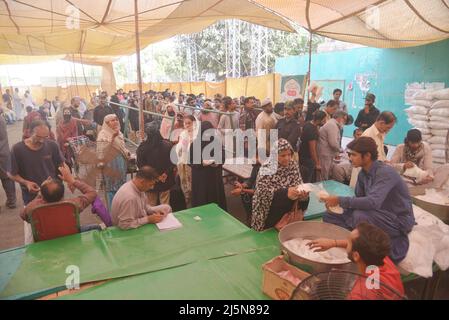 Lahore, Punjab, Pakistan. 24. April 2022. Pakistanische Menschen stehen in einer Schlange, als sie Zucker an einem Stand in Ramzan Sasta Bazar im Gebiet Shadman kaufen, wie es Premierminister Shehbaz Sharif, Die Regierung von Punjab würde ab Sonntag, dem 24. April, in Lahore Zucker zu einem subventionierten Satz von 70 Rs pro Kilogramm auf Ramazan-Basaren in der ganzen Provinz bereitstellen (Bildnachweis: © Rana Sajid Hussain/Pacific Press via ZUMA Press Wire) Stockfoto