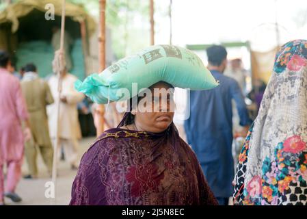 Lahore, Punjab, Pakistan. 24. April 2022. Pakistanische Menschen stehen in einer Schlange, als sie Zucker an einem Stand in Ramzan Sasta Bazar im Gebiet Shadman kaufen, wie es Premierminister Shehbaz Sharif, Die Regierung von Punjab würde ab Sonntag, dem 24. April, in Lahore Zucker zu einem subventionierten Satz von 70 Rs pro Kilogramm auf Ramazan-Basaren in der ganzen Provinz bereitstellen (Bildnachweis: © Rana Sajid Hussain/Pacific Press via ZUMA Press Wire) Stockfoto