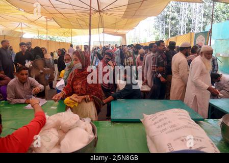 Lahore, Punjab, Pakistan. 24. April 2022. Pakistanische Menschen stehen in einer Schlange, als sie Zucker an einem Stand in Ramzan Sasta Bazar im Gebiet Shadman kaufen, wie es Premierminister Shehbaz Sharif, Die Regierung von Punjab würde ab Sonntag, dem 24. April, in Lahore Zucker zu einem subventionierten Satz von 70 Rs pro Kilogramm auf Ramazan-Basaren in der ganzen Provinz bereitstellen (Bildnachweis: © Rana Sajid Hussain/Pacific Press via ZUMA Press Wire) Stockfoto