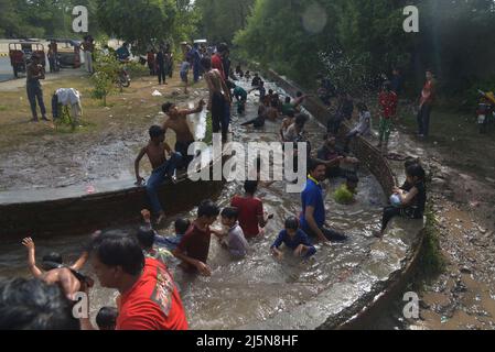 Lahore, Punjab, Pakistan. 24. April 2022. Pakistanische Jugendliche genießen ein Bad im Kanalwasser, um der Hitze zu entlasten und sich von dem warmen Wetter in Ramazan-ul-Mubarak in Lahore zu entlasten. (Bild: © Rana Sajid Hussain/Pacific Press via ZUMA Press Wire) Stockfoto