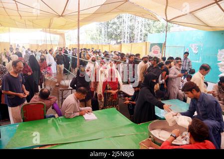 Lahore, Punjab, Pakistan. 24. April 2022. Pakistanische Menschen stehen in einer Schlange, als sie Zucker an einem Stand in Ramzan Sasta Bazar im Gebiet Shadman kaufen, wie es Premierminister Shehbaz Sharif, Die Regierung von Punjab würde ab Sonntag, dem 24. April, in Lahore Zucker zu einem subventionierten Satz von 70 Rs pro Kilogramm auf Ramazan-Basaren in der ganzen Provinz bereitstellen (Bildnachweis: © Rana Sajid Hussain/Pacific Press via ZUMA Press Wire) Stockfoto