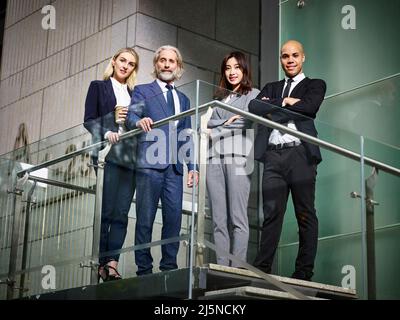 Team von multiethnischen Geschäftsleuten Männer und Frauen, die in einem modernen Bürogebäude stehen Stockfoto