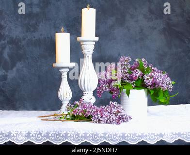 Hübsche zwei Säulen mit Kerzen und lila Flieder Stockfoto