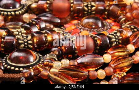 Halsketten und Armbänder auf schwarzem Hintergrund, Nahaufnahme lokaler Handwerksschmuck zum Verkauf Stockfoto