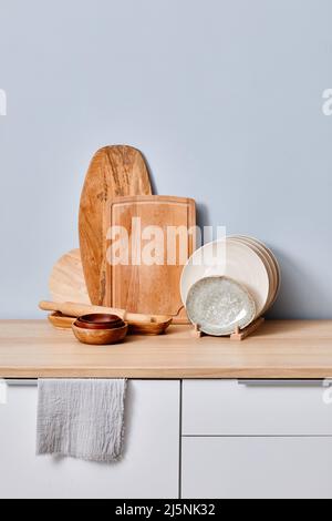 Bild von hölzernen Schneidebrettern, die in einer Reihe mit Platten auf einem Tisch stehen Stockfoto