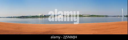 Panoramafoto der australischen Regierungsgebäude in der Hauptstadt Canberra, gesehen über den Burley Griffin Lake. Stockfoto