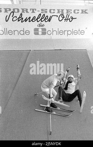 Walter Giller bei einer Werbeveranstaltung im Sporthaus Sport Scheck in München. Präsentiert wird die rollende Skipiste „schneller Otto“, auf der das Skifahren ausprobiert werden konnte. [Automatisierte Übersetzung] Stockfoto
