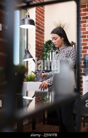 Unglückliche Geschäftsfrau verließ arbeitslos, sammelte persönliche Dinge im Büro. Unzufriedener Büroangestellter, der persönliche Gegenstände sammelt, nachdem er vom Geschäftsführer entlassen wurde. Stockfoto