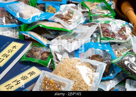 ZHONGSHAN GUANGDONG China-November 13 2021:Ansicht Einzelpackungen mit Kräutermedizin und zwei Bücher über traditionelle chinesische Kräuter. Stockfoto