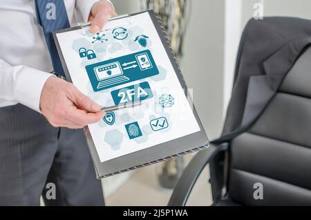 Geschäftsmann zeigt 2FA Konzept auf einem Clipboard Stockfoto