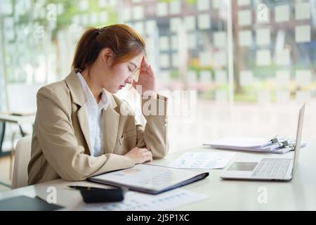 Burnout-Syndrom. Porträt der asiatischen Geschäftsfrau fühlt sich unbehaglich beim Arbeiten. Die durch Stress, durch erfolglose Arbeit angesammelt und weniger verursacht wird Stockfoto