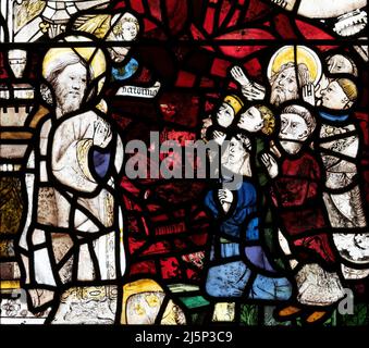 Mittelalterliche Glasmalerei mit St. Andrew und einer Familiengruppe, St. Andrew's Church, Greystoke, Cumbria, Großbritannien Stockfoto